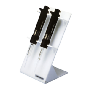Two black adjustable Nichiryo laboratory micropipettes sit in a white, angled Model 8100 Variable Repetitive Syringe Dispenser Stand against a plain background.