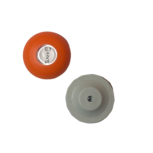 A Lambda Plus Push Button, Single Channel, 2μL (Labnet), orange and round with a “0.1” dial, sits beside a gray flat object with a central hexagonal hole on a white background.