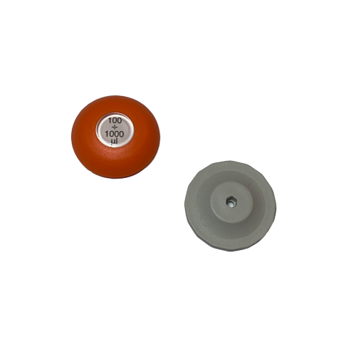 Two round objects are pictured on a white background: an orange Lambda Plus Push Button, Single Channel, 1000μL (Labnet) with a white label marked “100 μL ÷ 1000μL”, and a gray object with a central hole.