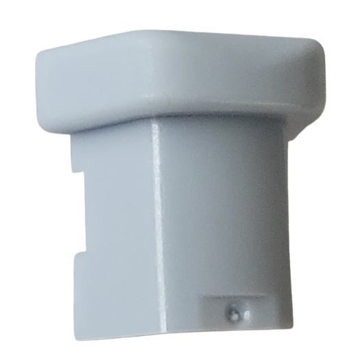 A close-up of a small, light gray plastic rectangular Nichiryo / Oxford Ejector Button, All Volumes (Nichiryo), featuring a slightly wider top and a small protrusion at the bottom.