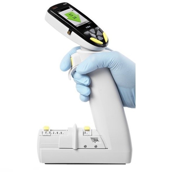 TS 4672060BT A gloved hand holds a Thermo Scientific E1-ClipTip Equalizer 384 Format Electronic Multichannel Pipette (8 Channel, 2-125μL) above its charging base, with display screen and control buttons visible.