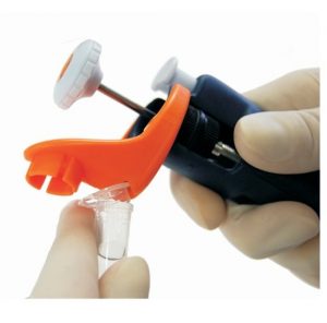 A gloved hand uses the Jimmy Microtube Opener for Pipetman Pipettes, 3 Pack (Gilson), to securely cap a small plastic vial.