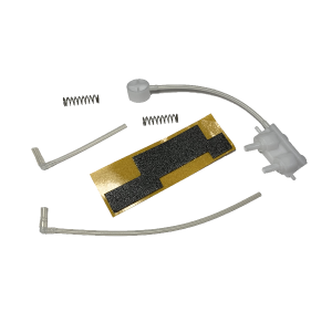 Assorted small mechanical parts from the Macroman, Older Version, Pneumatic Set (Gilson): two springs, plastic tubes, a white plastic piece, and a black-and-gold patterned adhesive strip arranged on a white background.