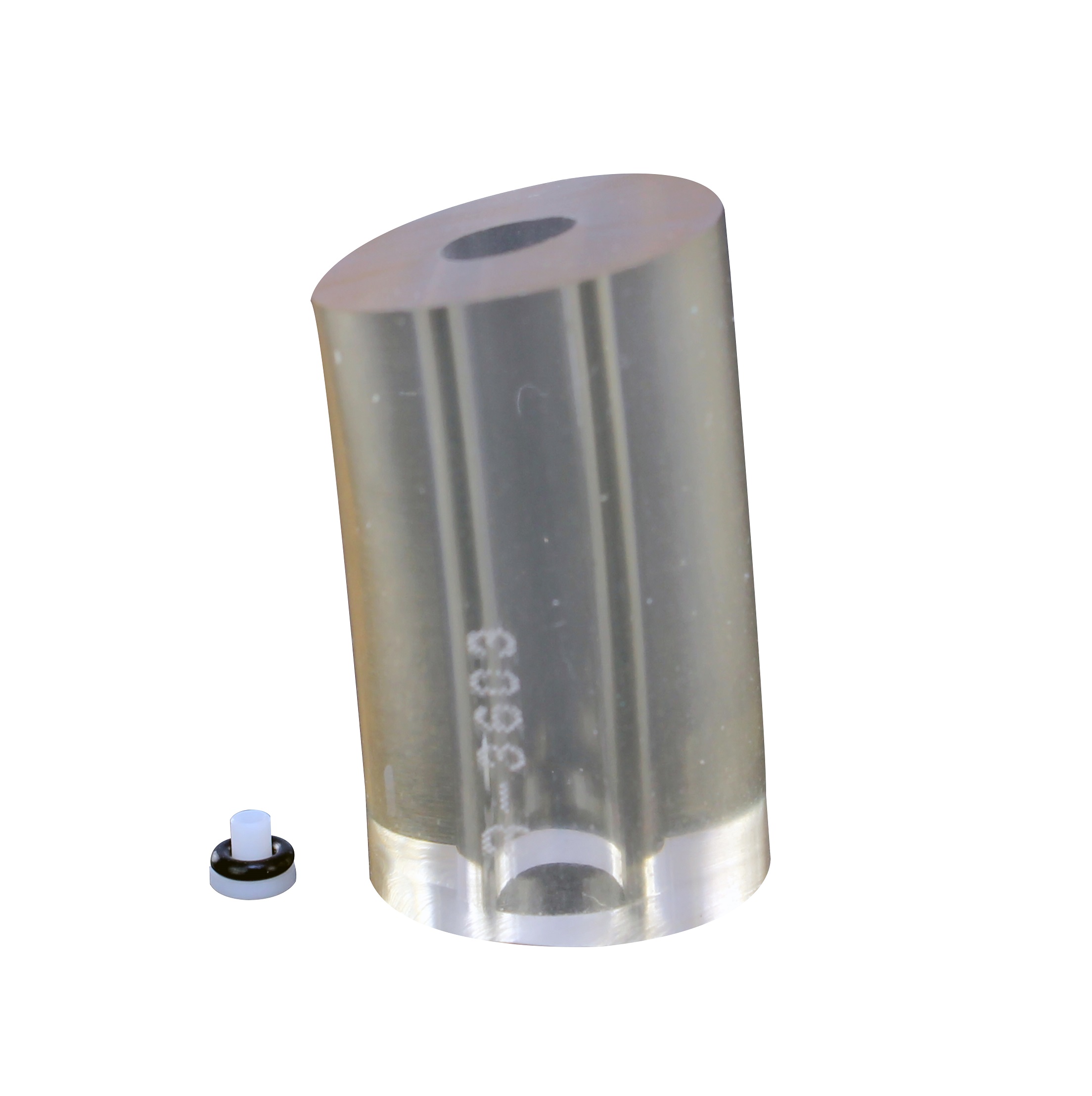 A large, transparent, cylindrical object with a hole through the center stands next to a small, round, black and white EDP Plus / EDP2 Seal Assembly, 10μL (Rainin), on a white background.