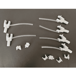 Six Rainin Nozzle Sets with Tubing, Adjustable Spacer Multichannel, 6 Channel, 300μL, are arranged on a black surface alongside six small plastic components.