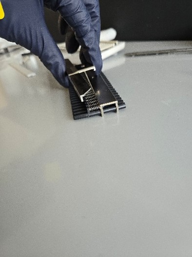 A gloved hand removes the metal plate, disassembling the Eppendorf Research Plus equipment during a nose cone replacement.