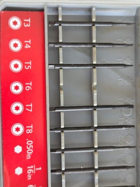 A close-up view of star-shaped screwdriver bits organized in a plastic case, ideal for tasks like Eppendorf Research Plus nose cone replacement, with size labels from T3 to T8 visible on a red panel. T6 missing.